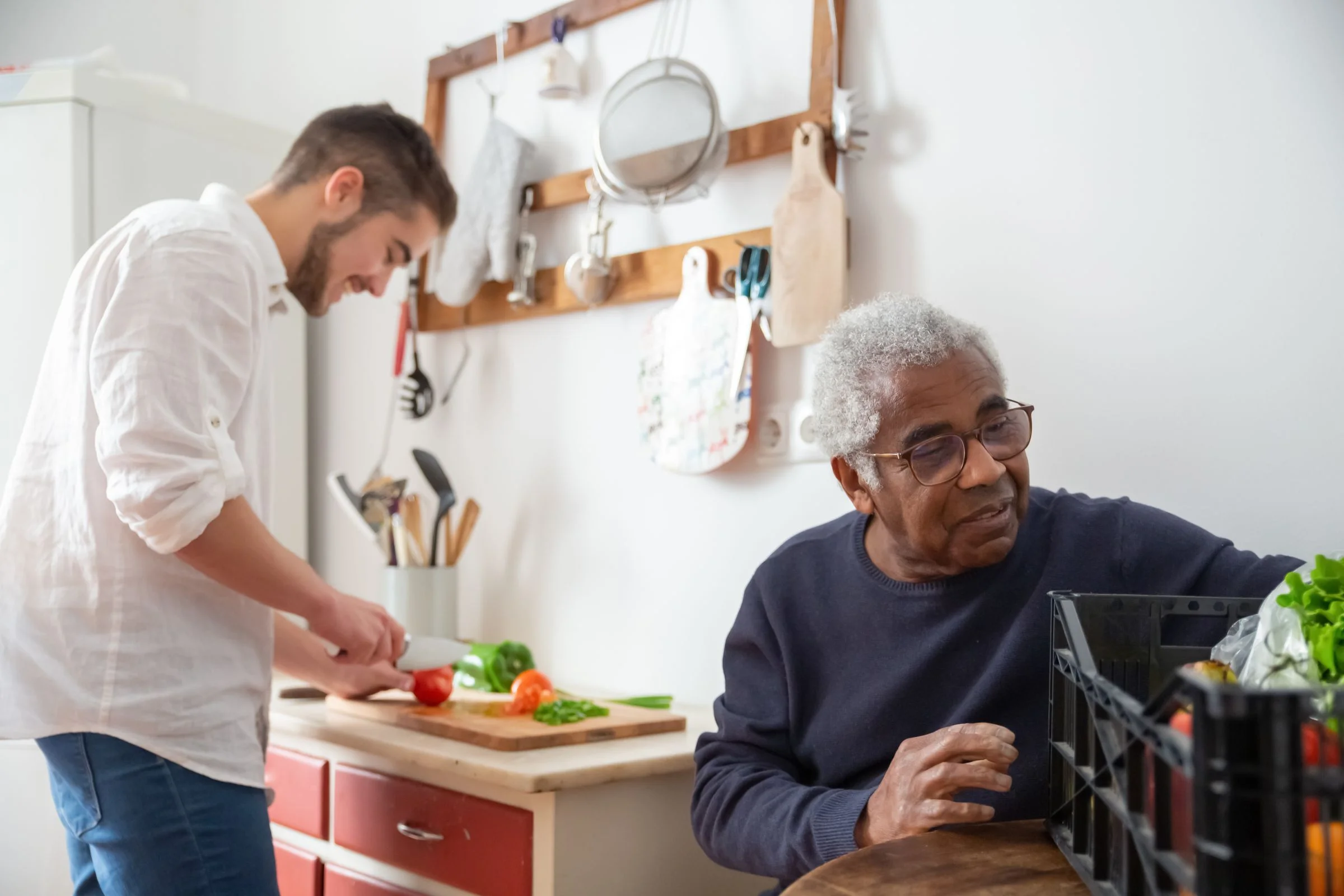 Ein Senior wird bei der Zubereitung einer Mahlzeit unterstützt
